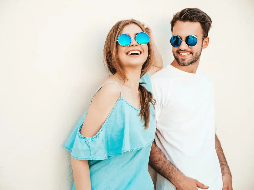 Stylish Summer Sunglasses for Men and Women Smiling young couple wearing trendy blue sunglasses in summer outfits