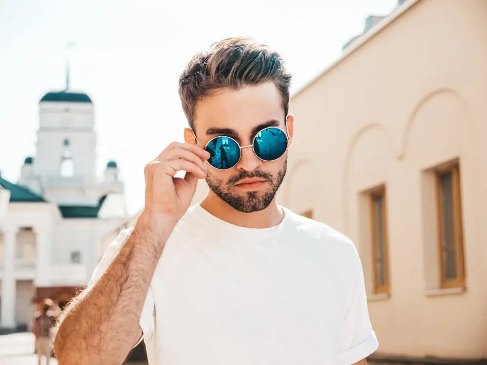 Trendy Round Blue Reflective Sunglasses – Urban Summer Street Style for Men Stylish man wearing round blue reflective sunglasses and white t-shirt on sunny day in urban setting
